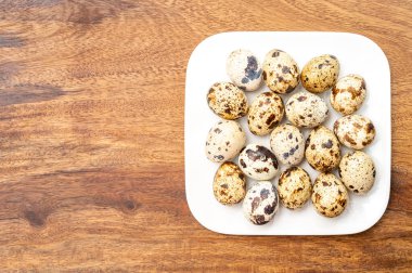 Beyaz tahtada taze küçük lekeli keklik yumurtaları.