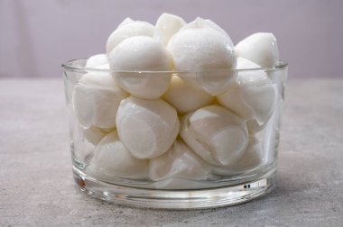 Peynir koleksiyonu, küçük yumuşak İtalyan mozzarella peyniri topları cam kasede Caprese salatası yapmaya hazır.