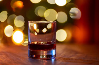 Edinburgh, İskoçya 'da arka planda parti ışıklarıyla birlikte barda servis edilen tek malt ve karışık viski bardakları