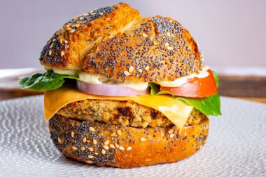 Lezzetli vejetaryen fast-food, portakallı mercimek, soğanlı baklagil, yeşil marul ve domatesli ev yapımı hamburgerler.