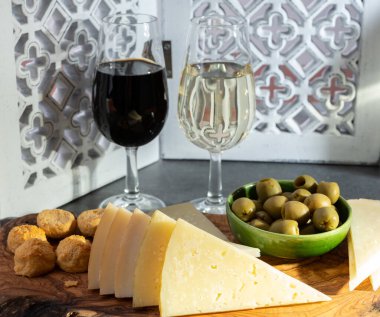 Tasting of fortified Andalusian dry fino and sweet sherry wine with traditional Spanisch tapas, green olives, goat and sheep manchego cheese clipart