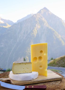 Peynir koleksiyonu, Fransız emmental, tomme ve reblochon de savoie peynirleri Savoy bölgesinde açık havada servis edilirken, yaz aylarında arka planda Alp dağları zirveleri yer almaktadır.