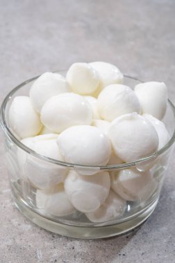 Peynir koleksiyonu, küçük yumuşak İtalyan mozzarella peyniri topları cam kasede Caprese salatası yapmaya hazır.