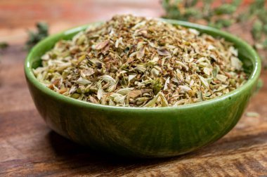 Kurutulmuş aromatik mutfak bitkisi yeşil kasede kekik otu yakın.