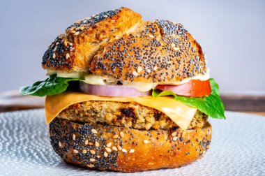 Lezzetli vejetaryen fast-food, portakallı mercimek, soğanlı baklagil, yeşil marul ve domatesli ev yapımı hamburgerler.
