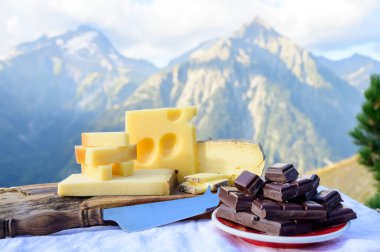 Lezzetli İsviçre peynirleri ve koyu saf çikolata, emmental, gruyere, appenzeller yaz aylarında arka planda Alp dağlarının zirveleriyle birlikte açık havada servis edildi.