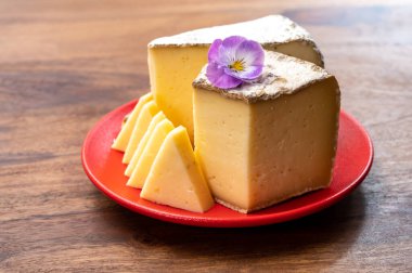 Peynir koleksiyonu, Fransız Alpleri 'ndeki Savoy bölgesinden Tomme de Savoie peyniri, bej rengi ve koyu kahverengi-gri kabuklu yumuşak inek sütü peyniri.