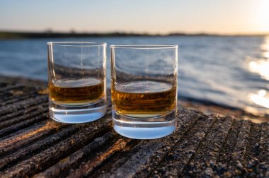 Gün batımında İskoç viskisi içmek deniz, okyanus veya nehir manzaralı, İskoçya, İngiltere 'de özel viski imalathanesi turları