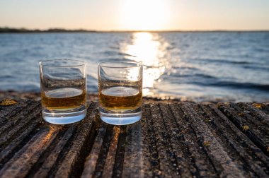 Gün batımında İskoç viskisi içmek deniz, okyanus veya nehir manzaralı, İskoçya, İngiltere 'de özel viski imalathanesi turları