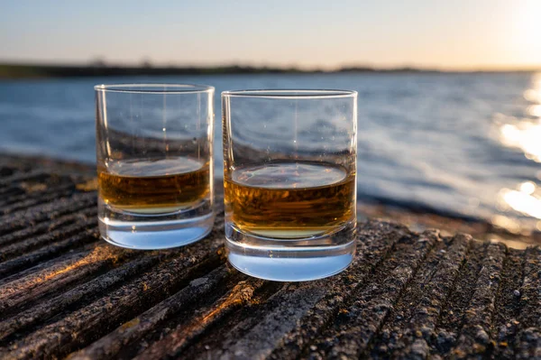 Gün batımında İskoç viskisi içmek deniz, okyanus veya nehir manzaralı, İskoçya, İngiltere 'de özel viski imalathanesi turları