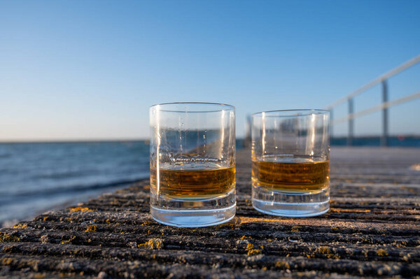 Drinking single malt Scotch whisky at sunset with sea, ocean or river view, private whisky distillery tours in Scotland, UK