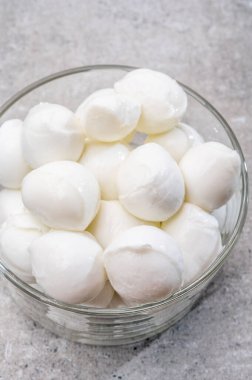 Peynir koleksiyonu, küçük yumuşak İtalyan mozzarella peyniri topları cam kasede Caprese salatası yapmaya hazır.