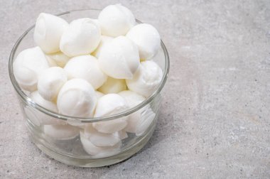 Peynir koleksiyonu, küçük yumuşak İtalyan mozzarella peyniri topları cam kasede Caprese salatası yapmaya hazır.