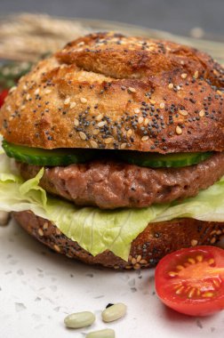 Bitki bazlı soya fasulyesi burgerinden lezzetli vejetaryen hamburger, tohumlu organik çörek ve taze sebze.