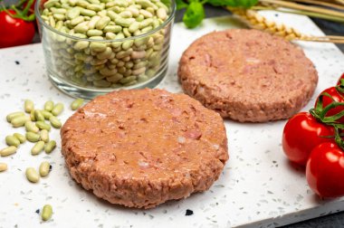Sağlıklı vejetaryen yemeği, çiğ bitki bazlı soya fasulyesi burgeri pişirmeye hazır.
