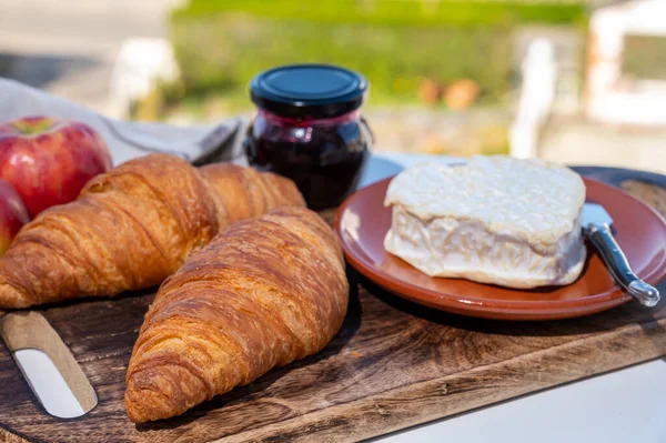 ノルマンディー産の焼きたてのクロワッサンとチーズを使ったフランス料理の朝食 キャンベルトとネフシャテルは素晴らしいフランスの村の景色を屋外で提供しています — ストック写真