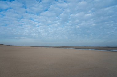 Küçük Belçika kasabası De Haan veya Le Coq sur mer 'deki sarı kumlu sahilde alçak uçuş süresi, lüks tatil beldesi, güneşli bir günde yaz tatili