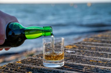 Gün batımında İskoç viskisi içmek deniz, okyanus veya nehir manzaralı, İskoçya, İngiltere 'de özel viski imalathanesi turları