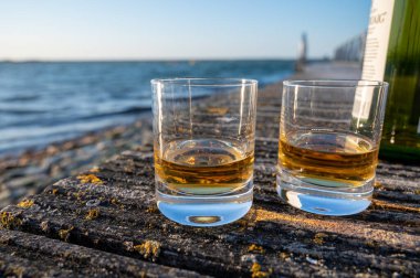 Gün batımında İskoç viskisi içmek deniz, okyanus veya nehir manzaralı, İskoçya, İngiltere 'de özel viski imalathanesi turları