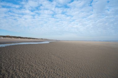 Küçük Belçika kasabası De Haan veya Le Coq sur mer 'deki sarı kumlu sahilde alçak uçuş süresi, lüks tatil beldesi, güneşli bir günde yaz tatili