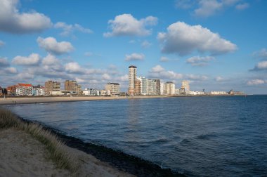 Rıhtım, kum tepeleri ve Vlissingen şehri, güneşli günbatımında kumlu plaj, Zeeland, Hollanda