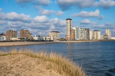 Rıhtım, kum tepeleri ve Vlissingen şehri, güneşli günbatımında kumlu plaj, Zeeland, Hollanda