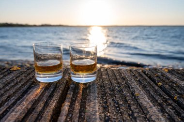 Gün batımında İskoç viskisi içmek deniz, okyanus veya nehir manzaralı, İskoçya, İngiltere 'de özel viski imalathanesi turları