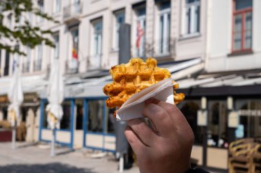 Taze pişmiş Belçika şekerli waffle 'lar, Bruges' de sokak yemekleri yemek.