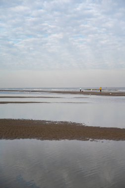 Küçük Belçika kasabası De Haan veya Le Coq sur mer 'deki sarı kumlu sahilde alçak uçuş süresi, lüks tatil beldesi, güneşli bir günde yaz tatili