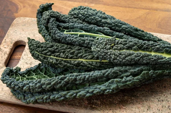 Vegetarian cooking with black flat leaves of cavolo nero tuscan cabbage
