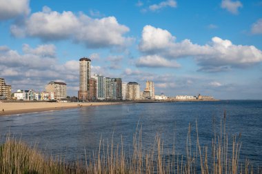 Rıhtım, kum tepeleri ve Vlissingen şehri, güneşli günbatımında kumlu plaj, Zeeland, Hollanda