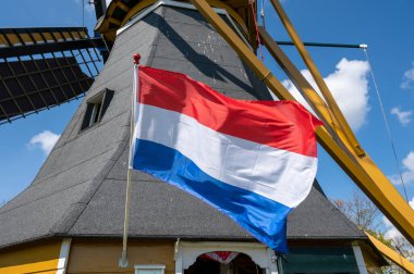 Hollanda bayrağı ve arka planda tahıl öğütmek için kullanılan eski geleneksel yel değirmeni