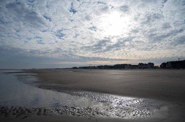 Küçük Belçika kasabası De Haan veya Le Coq sur mer 'deki sarı kumlu sahilde alçak uçuş süresi, lüks tatil beldesi, güneşli bir günde yaz tatili