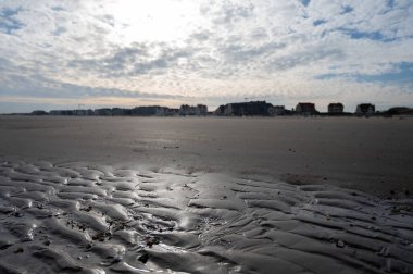 Küçük Belçika kasabası De Haan veya Le Coq sur mer 'deki sarı kumlu sahilde alçak uçuş süresi, lüks tatil beldesi, güneşli bir günde yaz tatili