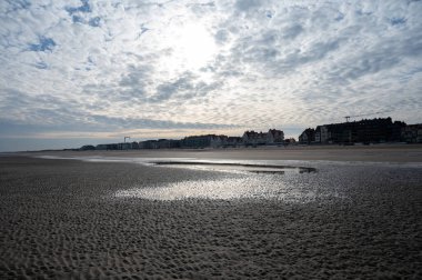 Küçük Belçika kasabası De Haan veya Le Coq sur mer 'deki sarı kumlu sahilde alçak uçuş süresi, lüks tatil beldesi, güneşli bir günde yaz tatili