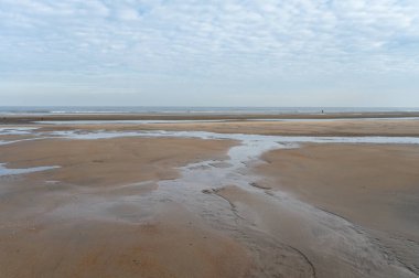 Küçük Belçika kasabası De Haan veya Le Coq sur mer 'deki sarı kumlu sahilde alçak uçuş süresi, lüks tatil beldesi, güneşli bir günde yaz tatili