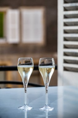 Romantik bir parti, iki bardak soğuk şampanya köpüklü köpüklü köpüklü şarap ve Fransız köyündeki eski cadde manzaralı.