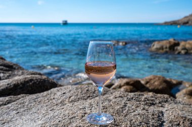 Provence 'de yaz zamanı, kumlu sahilde bir bardak soğuk gül şarabı ve güneşli bir günde Saint-Tropez yakınlarında mavi deniz suyu, Var Bölümü, Fransa