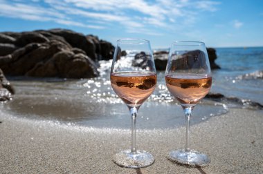 Provence 'de yaz mevsimi, güneşli bir günde Saint-Tropez yakınlarındaki kumlu sahilde iki bardak soğuk gül şarabı, Var Bölümü, Fransa