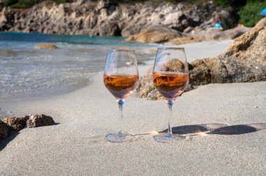 Provence 'de yaz mevsimi, güneşli bir günde Saint-Tropez yakınlarındaki kumlu sahilde iki bardak soğuk gül şarabı, Var Bölümü, Fransa