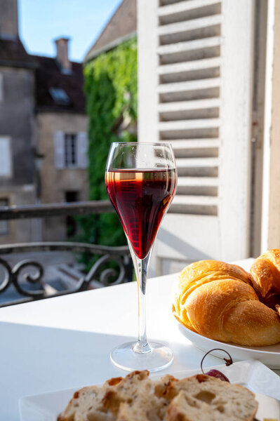 Выпивка Королевского Кира, французского аперитива коктейль из крем-де-Касси увенчанный шампанским, как правило, подается в бокалах с флейтой, с видом на старую французскую деревню