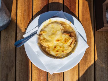 Fransız karamelli soğan çorbası, kızarmış ekmek ve fırından çıkan gruyere peyniri.