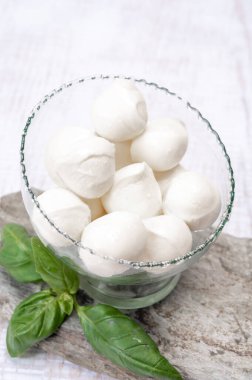 Taze, yumuşak mozzarella topları taze yeşil fesleğenle servis ediliyor.