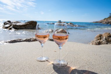 Provence 'de yaz mevsimi, güneşli bir günde Saint-Tropez yakınlarındaki kumlu sahilde iki bardak soğuk gül şarabı, Var Bölümü, Fransa