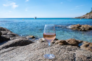 Provence 'de yaz zamanı, kumlu sahilde bir bardak soğuk gül şarabı ve güneşli bir günde Saint-Tropez yakınlarında mavi deniz suyu, Var Bölümü, Fransa