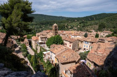 Fransa 'nın Provence kentindeki Moustiers-Sainte-Marie kasabasındaki dağlık uçurum, eski evler, yeşil vadi. Turistik bir yer.