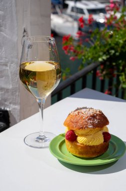 Tarte tropezienne ya da La Tarte de Saint-Tropez. Açık havada servis edilen kremalı ve taze meyveli çöreklerden oluşan tatlı tatlısı. Bir kadeh beyaz şarapla.