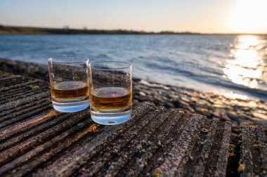 Gün batımında İskoç viskisi içmek deniz, okyanus veya nehir manzaralı, İskoçya, İngiltere 'de özel viski imalathanesi turları