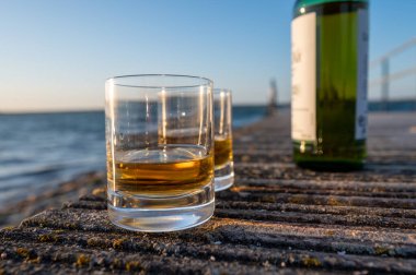 Gün batımında İskoç viskisi içmek deniz, okyanus veya nehir manzaralı, İskoçya, İngiltere 'de özel viski imalathanesi turları