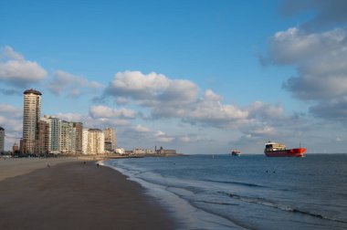 Rıhtım, kum tepeleri ve Vlissingen şehri, güneşli günbatımında kumlu plaj, Zeeland, Hollanda